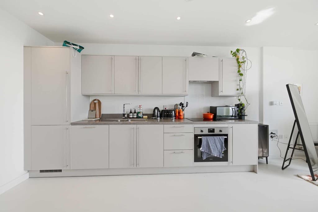 Modern kitchen with kettle, toaster, utensils and clutter on the worktops before cleanup